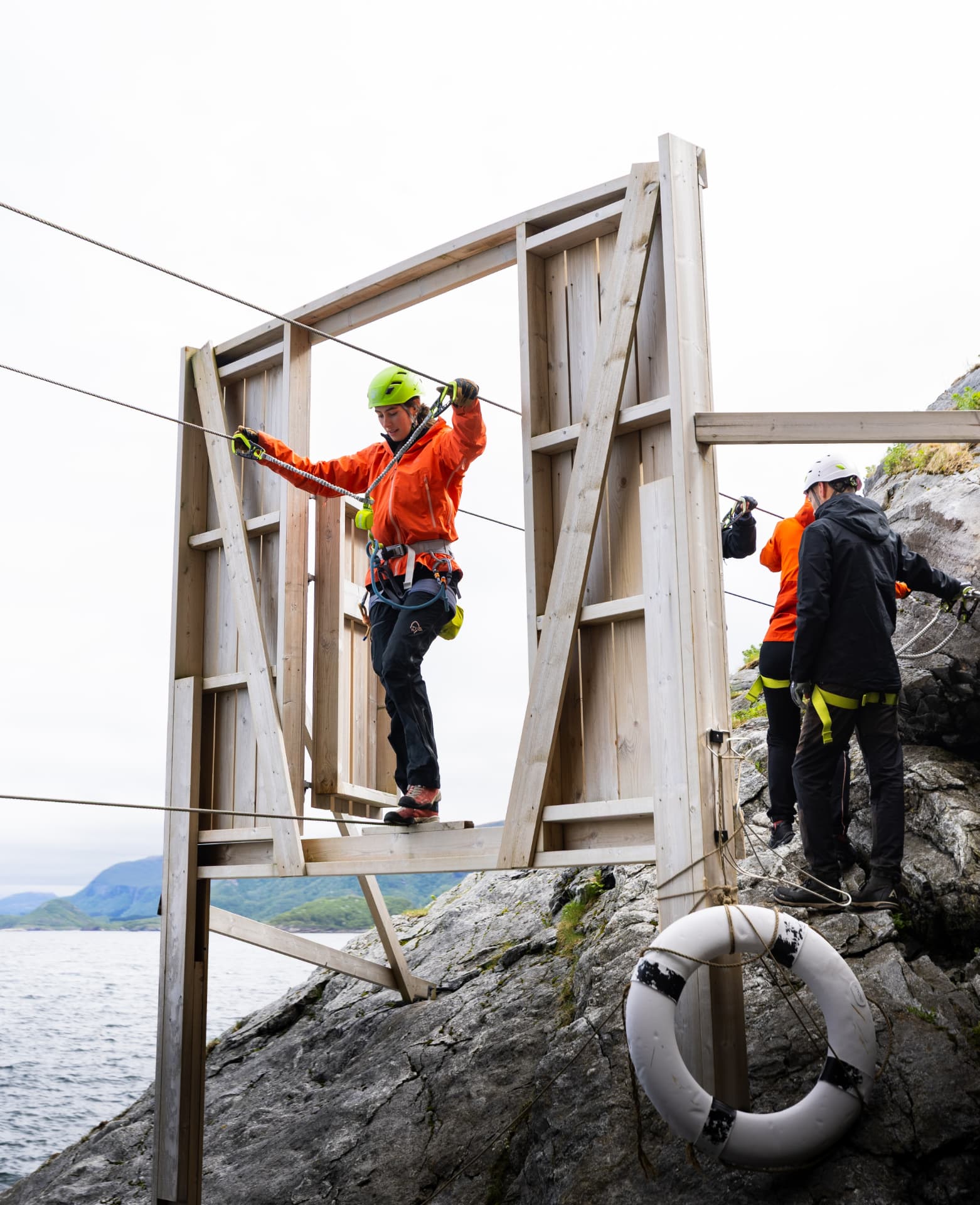 Participants franchissant un obstacle de via ferrata au-dessus de la mer à Bodø